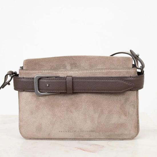 Gray suede handbag with a brown strap on a white background
