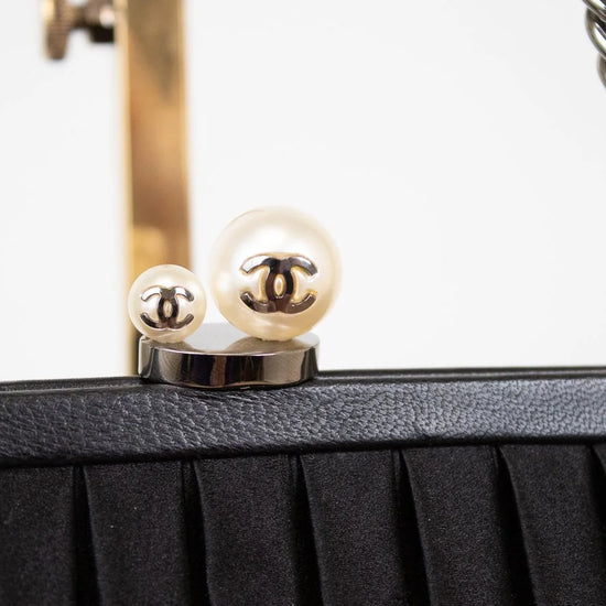 Close-up of a black handbag with Chanel logo on a white background