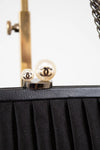 Close-up of a black handbag with Chanel logo on a white background