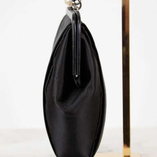 Black handbag with a chain strap on a white background