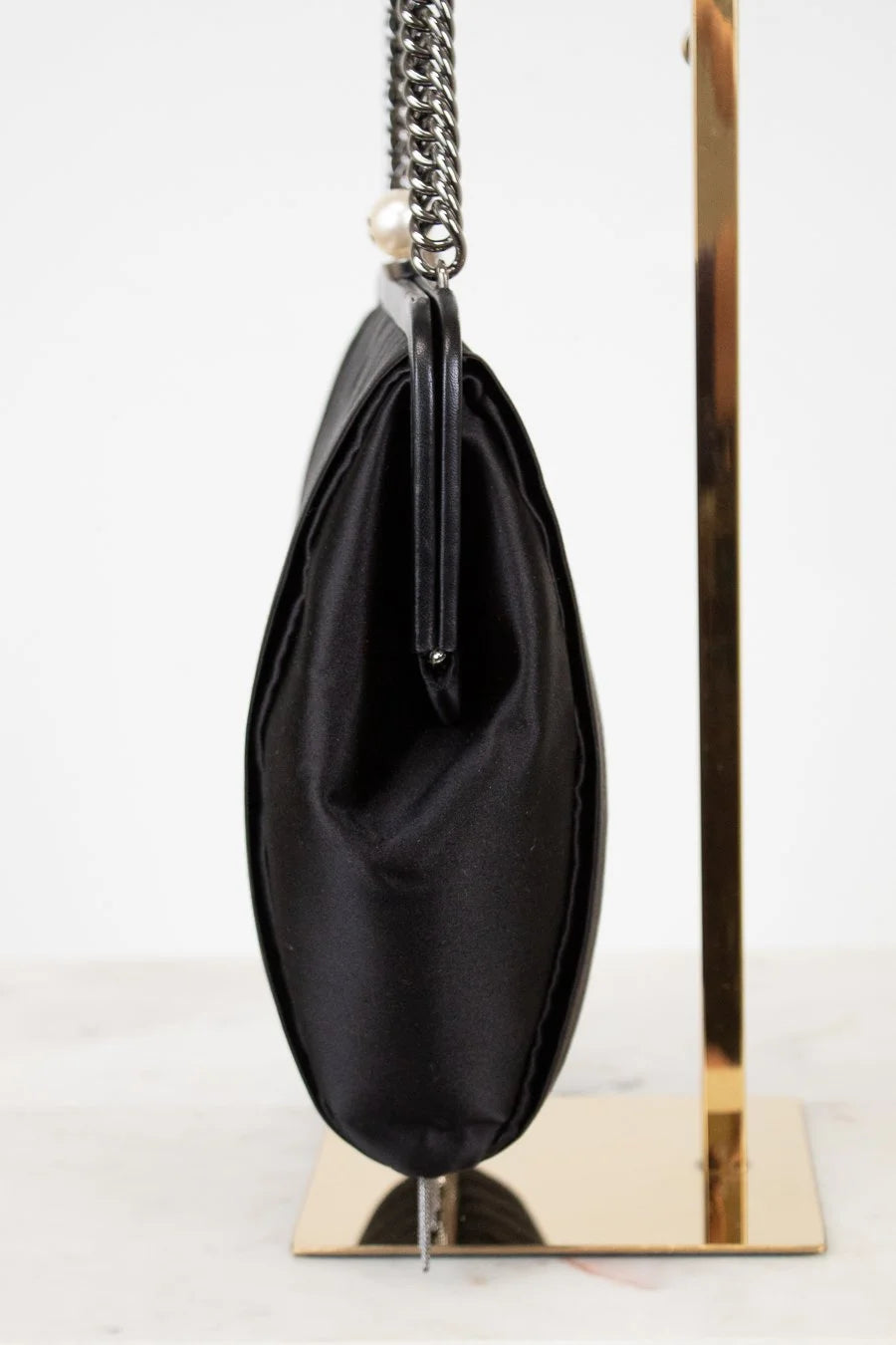 Black handbag with a chain strap on a white background