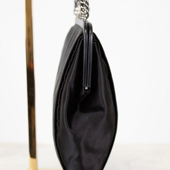 Black clutch bag with a chain strap on a white background