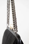 Black handbag with a silver chain strap on a white background