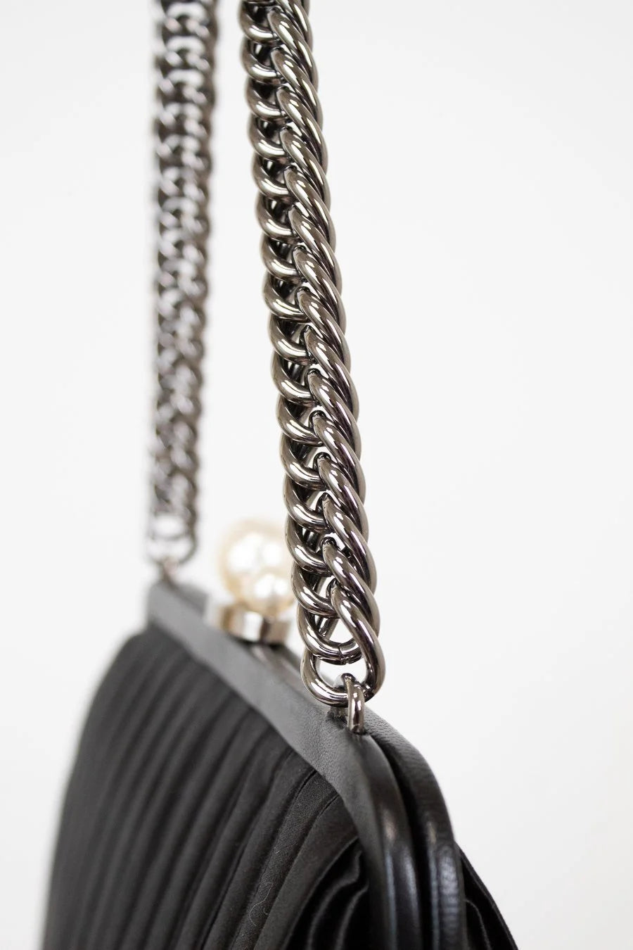 Black handbag with a silver chain strap on a white background