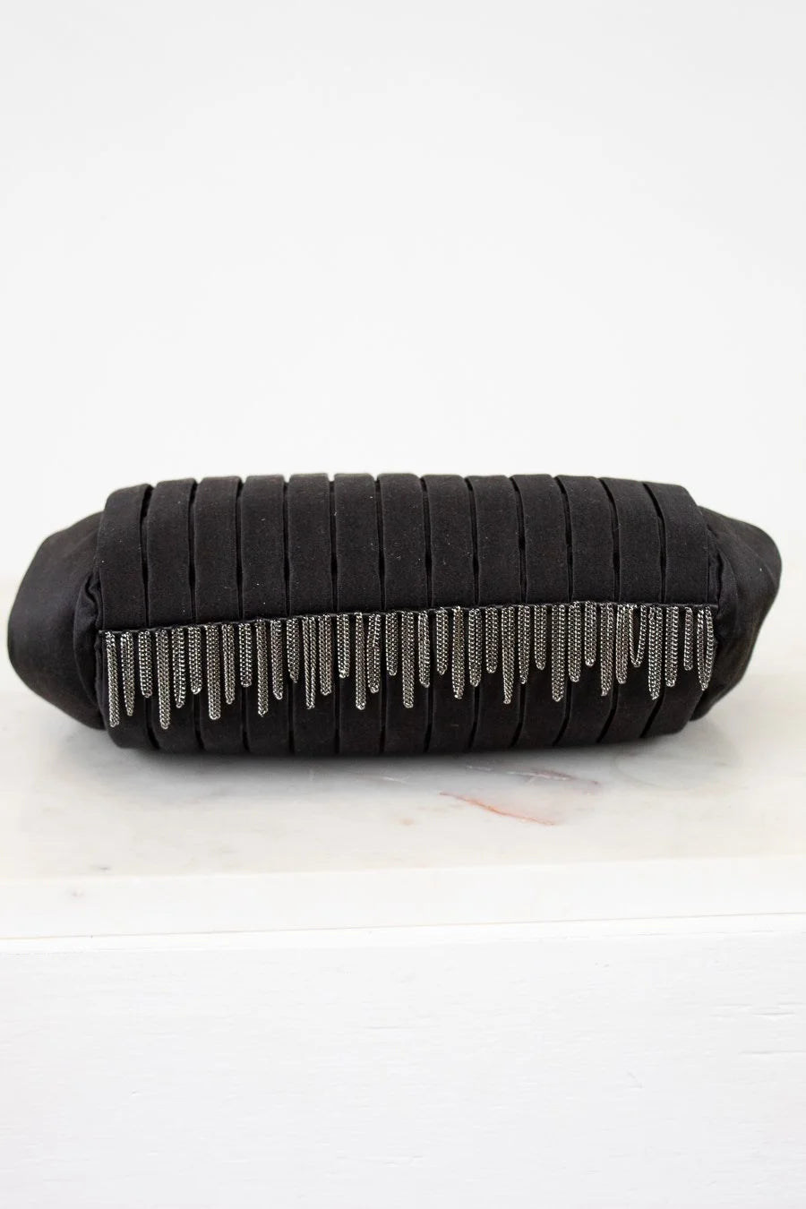 Black clutch bag with silver fringe on a white background