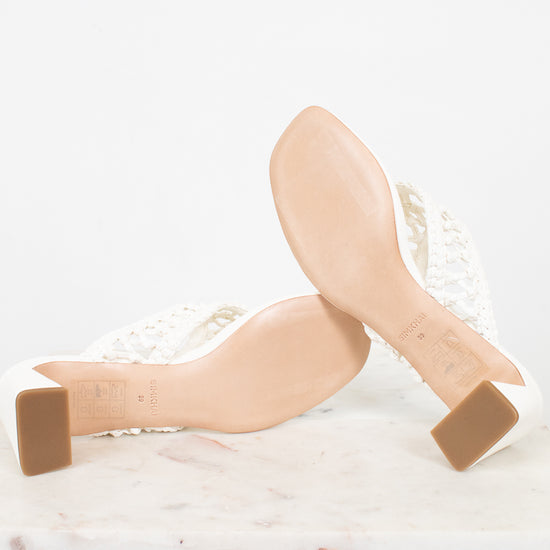 White block-heeled shoes with beige soles on a white background