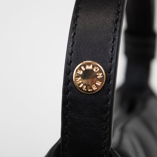 Close-up of a black leather strap with a gold logo on a white background