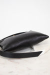 Black leather handbag on a light marble surface