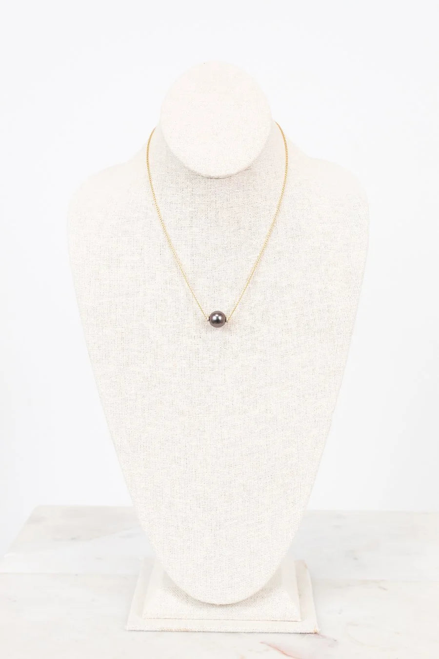 Pearl necklace on a mannequin with a white background