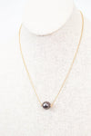 Necklace with a single black pearl on a white background