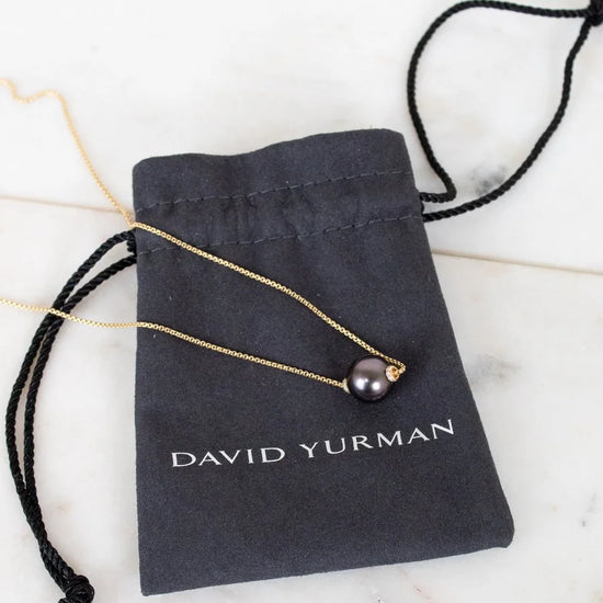 David Yurman necklace on a branded pouch with a marble background