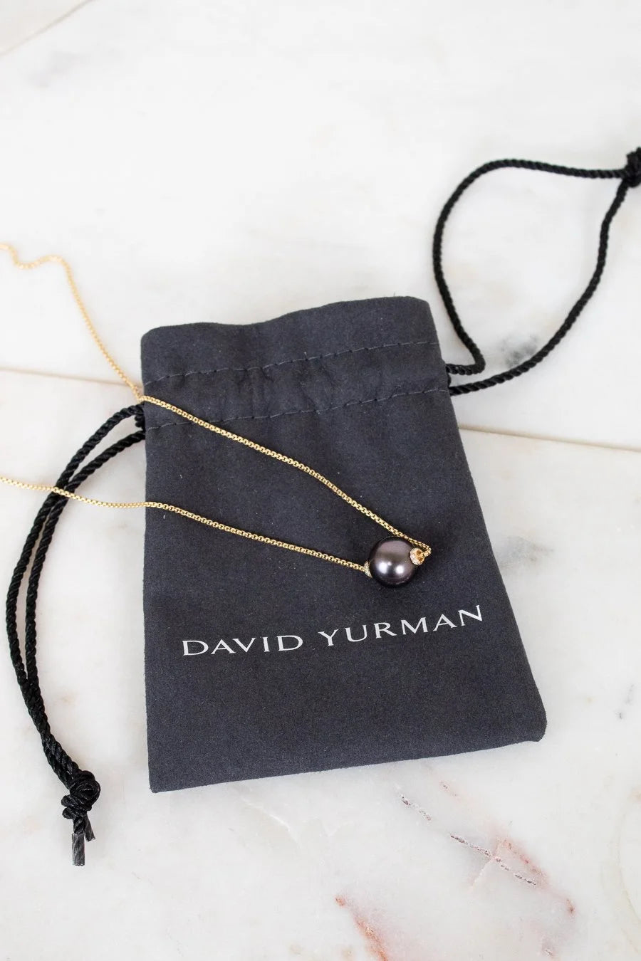 David Yurman necklace on a branded pouch with a marble background