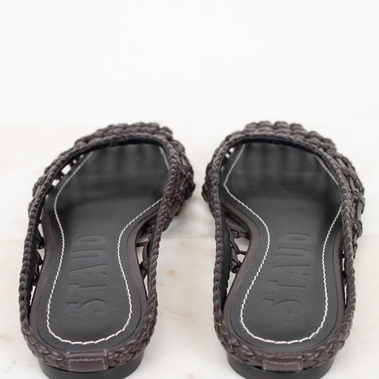 Pair of dark brown sandals with woven design on a white background