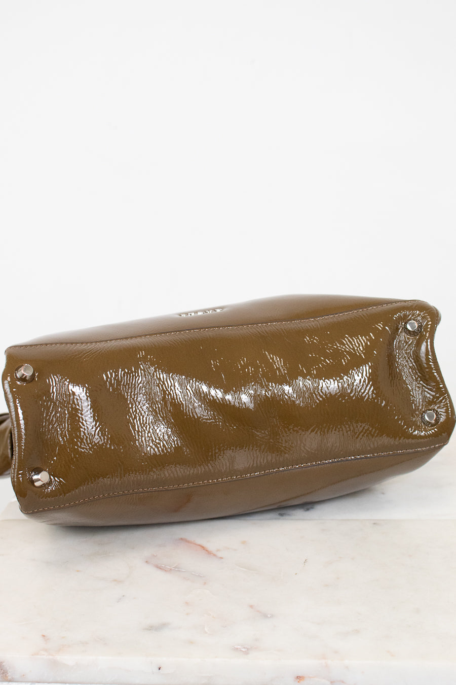 Olive leather handbag on a marble surface