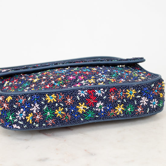 Bottom view of multicolored floral beaded bag on a white surface