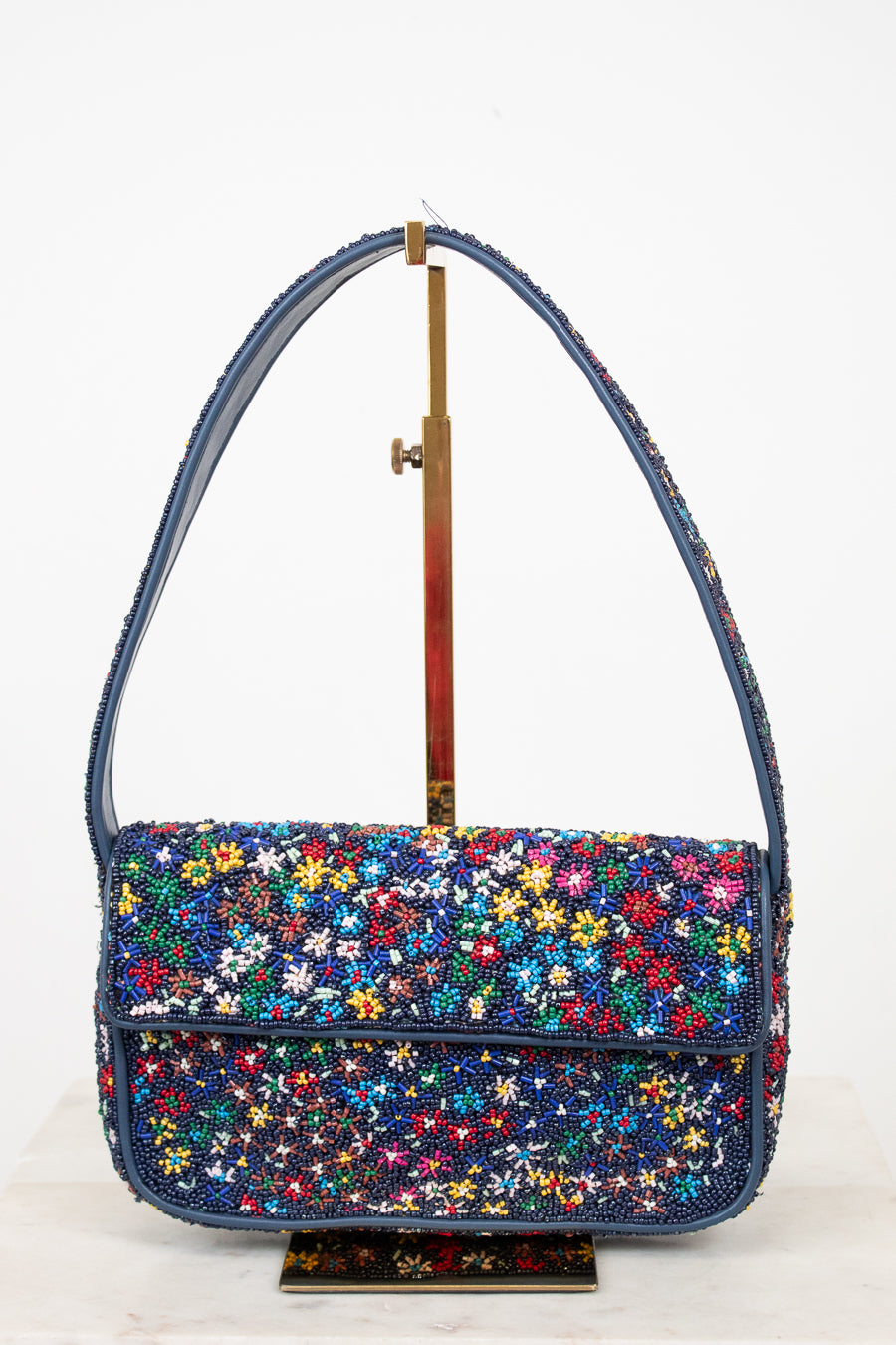 Multicolored floral-patterned beaded handbag on a white background
