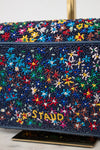 Multicolored beaded handbag with 'STAUD' branding on a light background