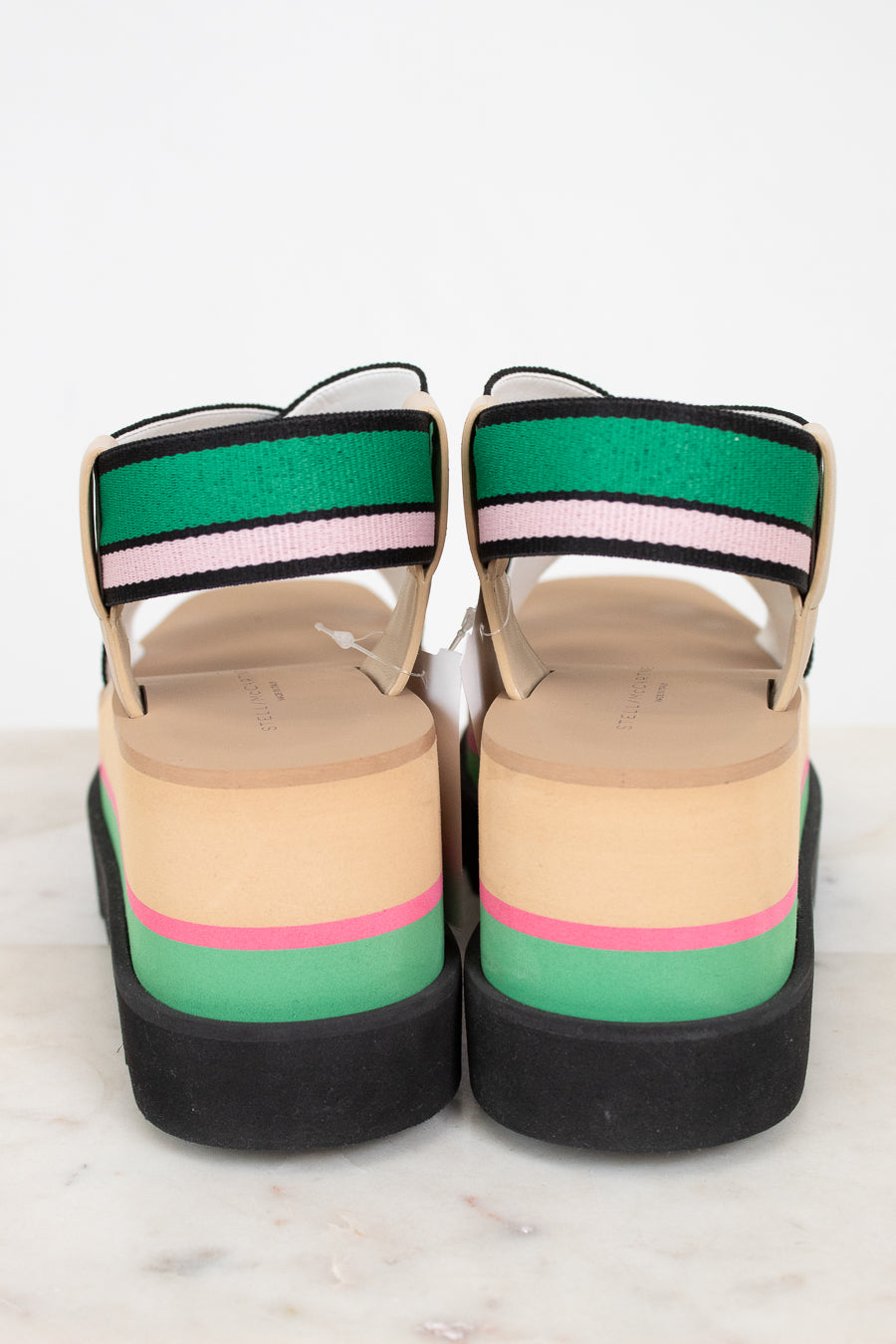 Colorful platform sandals with striped straps on a white background