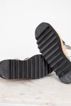 Close-up of a black rubber sole on a shoe with a white background