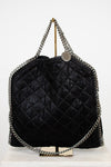 Black quilted handbag with chain details on a white background