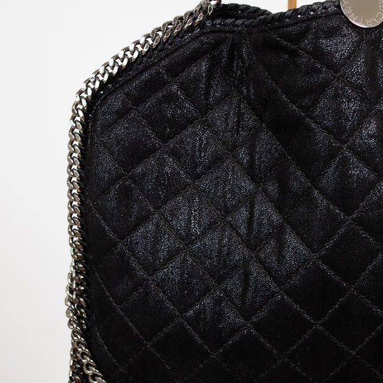 Black quilted handbag with chain strap on a white background