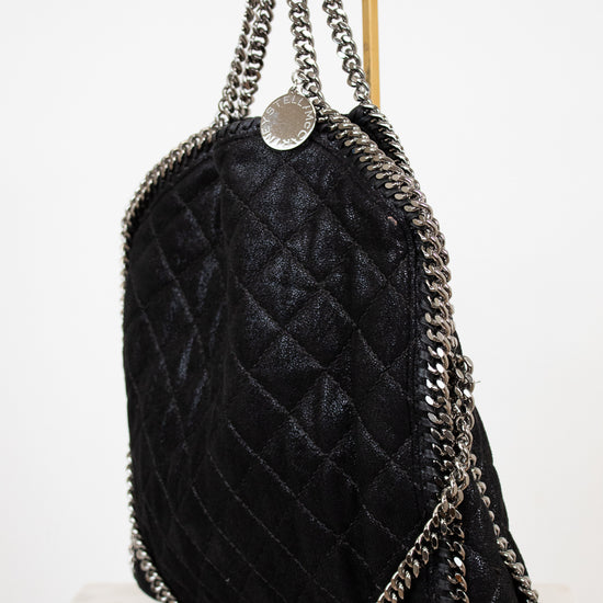 Black quilted handbag with silver chain straps on a white background