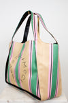 Straw bag with colorful stripes and text on a white background