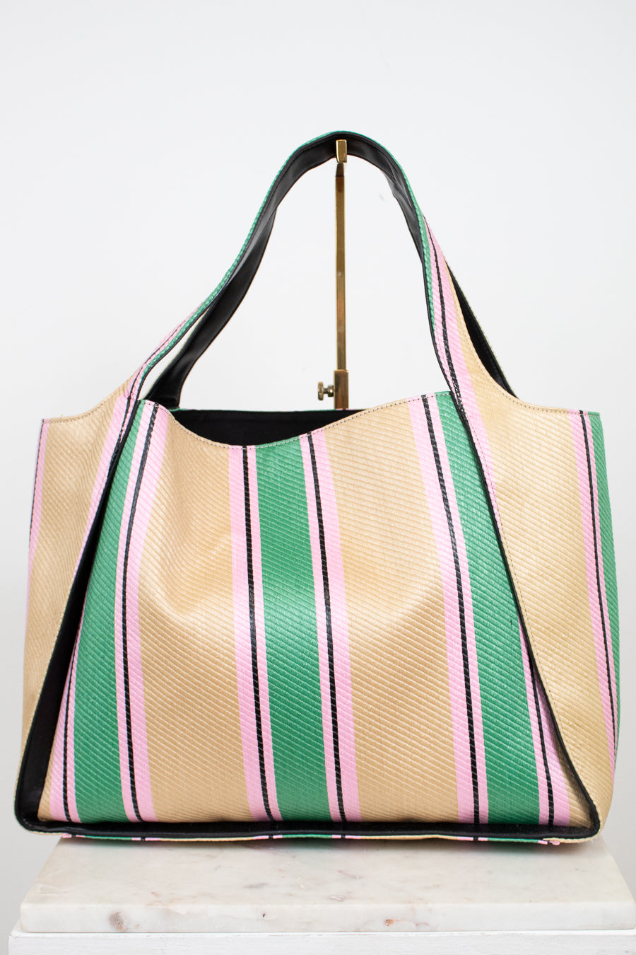 Striped handbag with green, pink, and beige colors on a white background