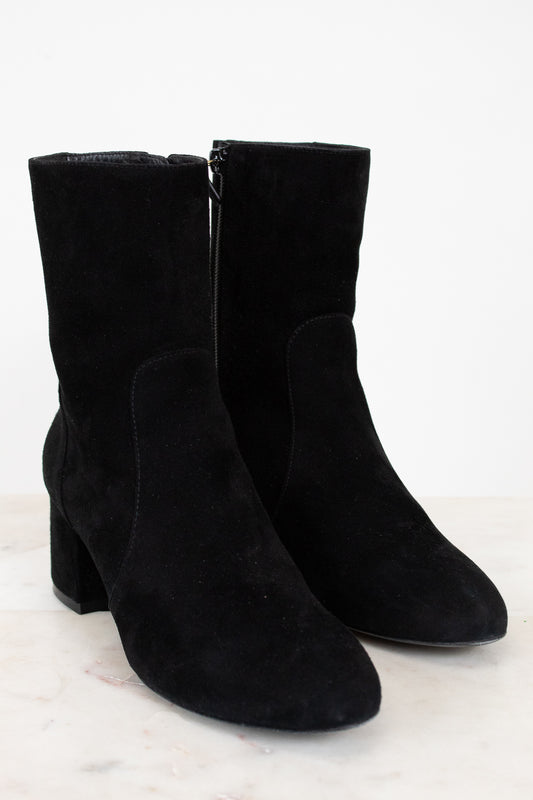 Pair of black suede boots on a white background