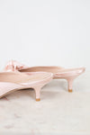 Pair of pink kitten-heeled shoes on a light marble surface