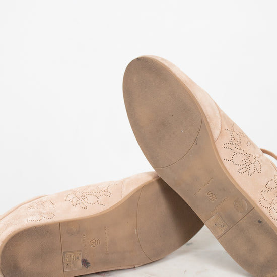 Brown leather shoe soles on a marble surface with a white background