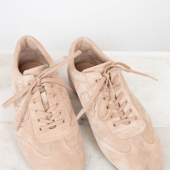 Pair of beige sneakers on a light marble surface