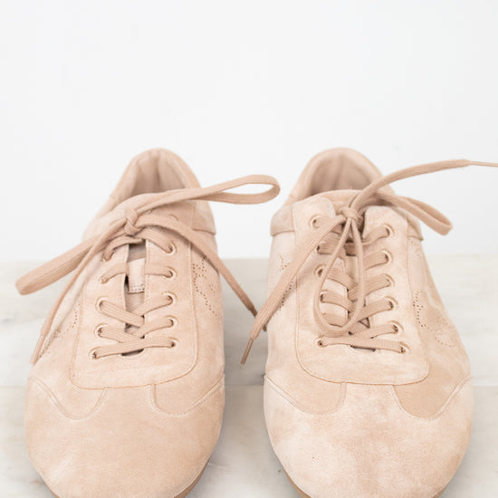 Pair of beige sneakers on a light marble surface