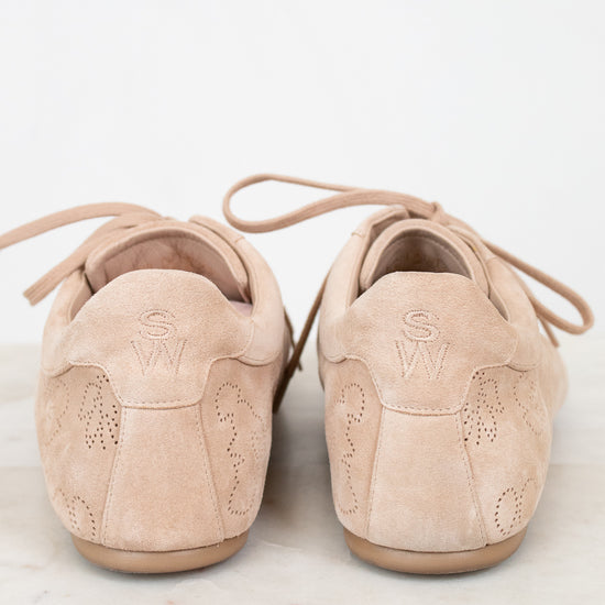 Pair of beige suede shoes on a light marble surface