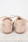 Pair of beige suede shoes on a light marble surface