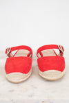 Pair of red espadrille sandals on a light wooden surface