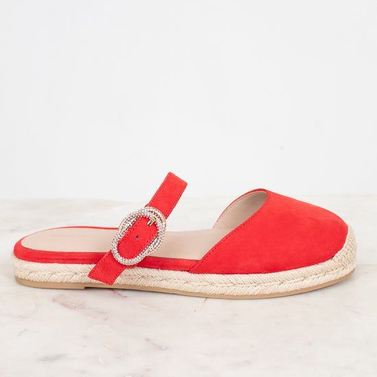 Red sandal with a buckle on a light background