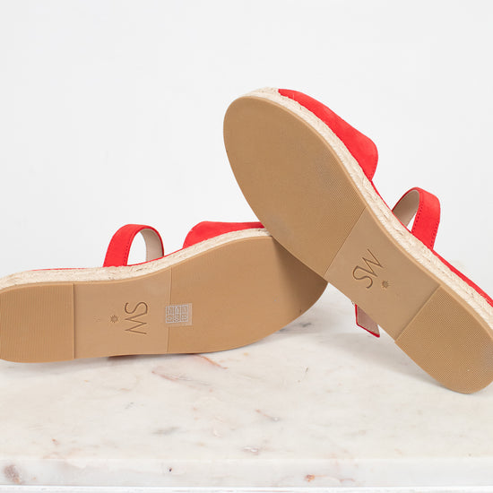 Red sandals with tan soles on a white background