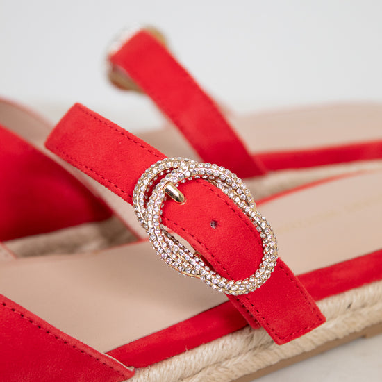 Red sandal with a decorative buckle on a light background