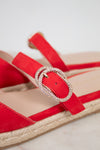 Red sandal with a decorative buckle on a light background