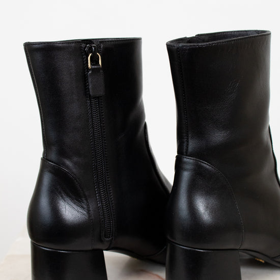 Pair of black leather boots on a light background