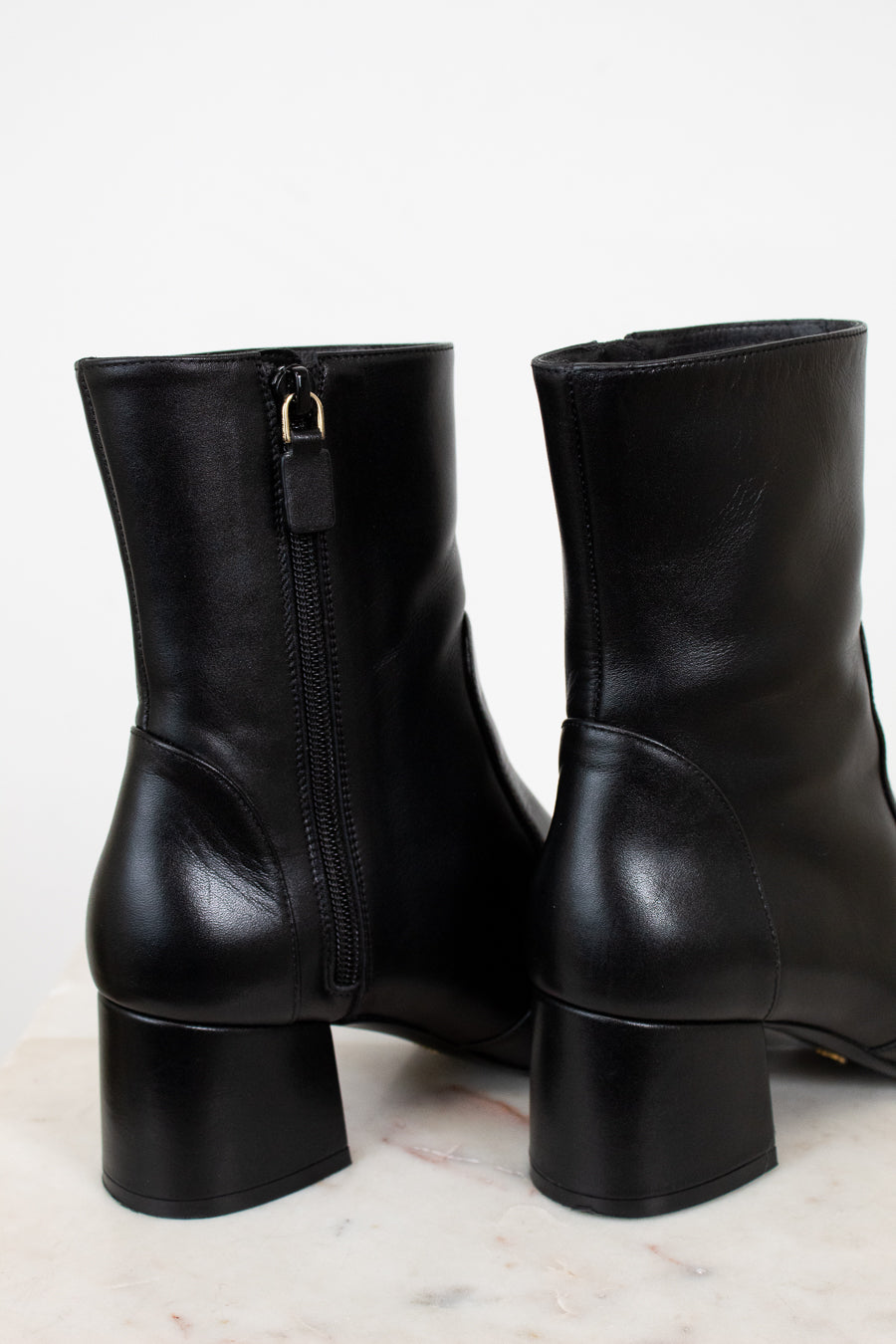 Pair of black leather boots on a light background