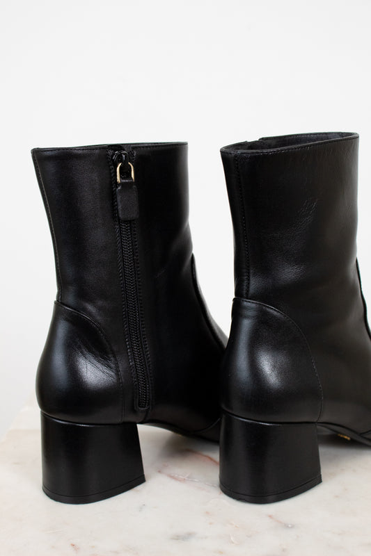 Pair of black leather boots on a light background