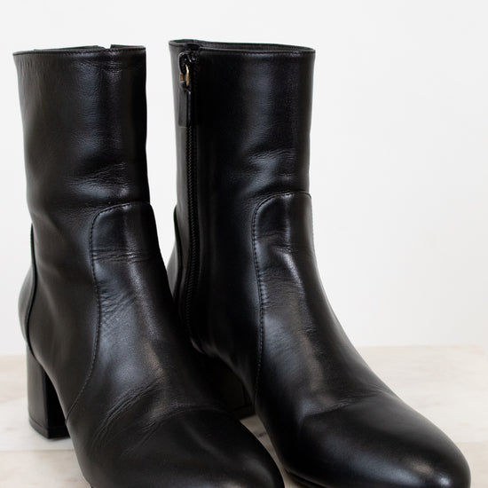 Pair of black leather ankle boots on a light background