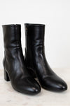 Pair of black leather ankle boots on a light background