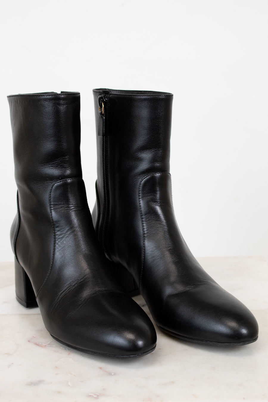 Pair of black leather ankle boots on a light background