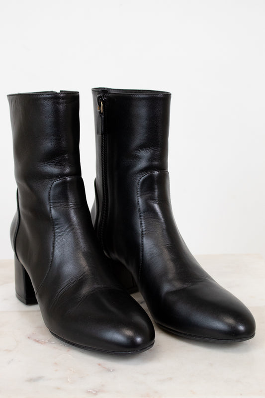 Pair of black leather ankle boots on a light background