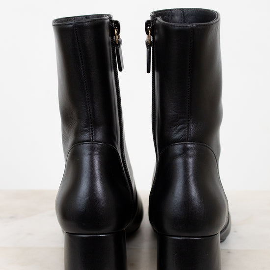 Pair of black leather boots on a marble surface
