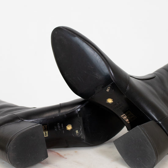 Black leather boots on a marble surface