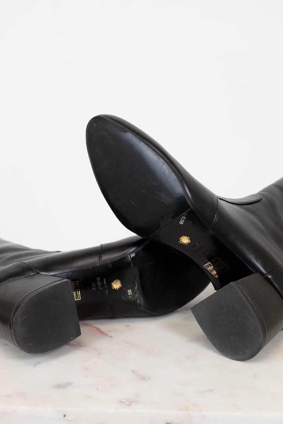 Black leather boots on a marble surface